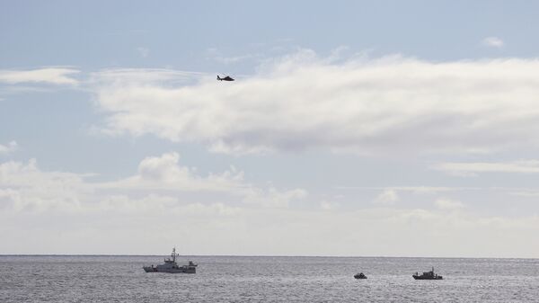 A U.S. Coast Guard helicopter flies over rescue boats at the scene of plane crash off Honolulu, Wednesday, Dec. 12, 2018 - Sputnik International