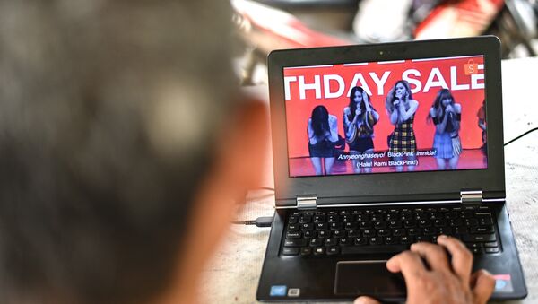 A man watches a commercial featuring K-pop supergroup Blackpink on his laptop in Jakarta on December 12, 2018, after the advertisement was banned by the Indonesian Broadcasting Commission. - Sputnik International