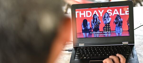 A man watches a commercial featuring K-pop supergroup Blackpink on his laptop in Jakarta on December 12, 2018, after the advertisement was banned by the Indonesian Broadcasting Commission. - Sputnik International