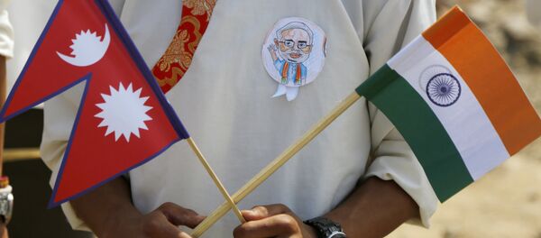 A school student holds a Nepalese and Indian flag and wears a badge with a portrait of Indian Prime Minister Narendra Modi as he waits to welcome Modi in Kathmandu, Nepal, Friday, May 11, 2018 A school student holds a Nepalese and Indian flag and wears a badge with a portrait of Indian Prime Minister Narendra Modi as he waits to welcome Modi in Kathmandu, Nepal, Friday, May 11, 2018 - Sputnik International