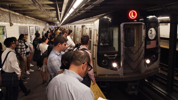 Commuters wait on a platform as the L subway train arrives in the 1st Avenue station. - Sputnik International
