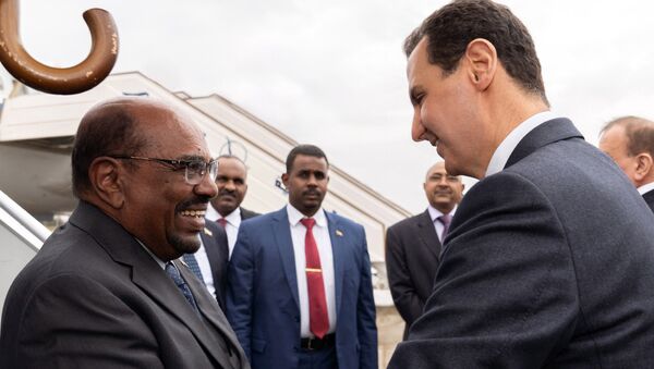 In this photo released by the Syrian official news agency SANA, Syrian President Bashar Assad, right, shakes hands with Sudan's President Omar al-Bashir in Damascus, Syria, Sunday, Dec. 16, 2018. - Sputnik International