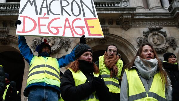 French activist Jean-Baptiste Redde, aka Voltuan, wearing a yellow vest (gilet jaune) holds a cardboard reading Macron go away during a demonstration in front of the Opera House in Paris against rising costs of living blamed on high taxes, on December 15, 2018 - Sputnik International