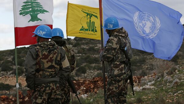 In this Thursday, Dec. 13, 2018 photo, UN peacekeepers hold their flag while standing next to Hezbollah and Lebanese flags, at the site where Israeli excavators are working, near the southern border village of Mays al-Jabal, Lebanon - Sputnik International