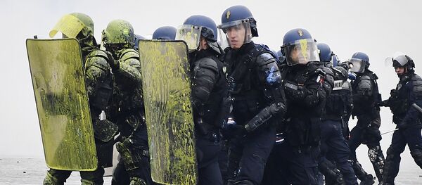 Riot police officers stand in position during clashes with demonstrators during a protest of Yellow vests (Gilets jaunes) against rising oil prices and living costs on the Champs Elysees in Paris, on December 1, 2018 - Sputnik International