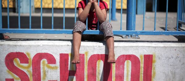 In this Monday, July 14, 2014 photo, a Palestinian girl sits on the wall of the New Gaza United Nations School, where dozens of families have sought refuge after fleeing their home in fear of Israeli airstrikes In this Monday, July 14, 2014 photo, a Palestinian girl sits on the wall of the New Gaza United Nations School, where dozens of families have sought refuge after fleeing their home in fear of Israeli airstrikes - Sputnik International