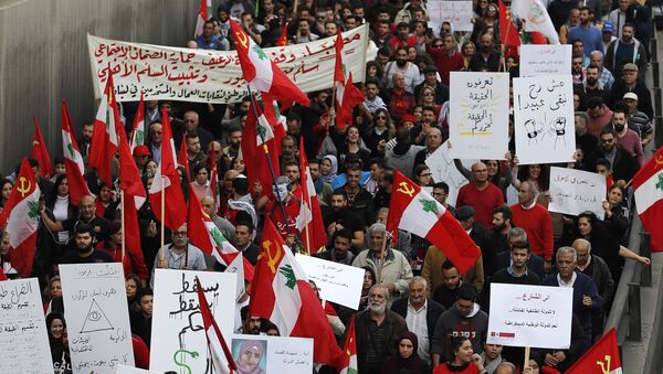 Anti-government demonstrators hold banners during a march organized by the country's communist party, in Beirut, Lebanon, Sunday, Dec. 16, 2018. - Sputnik International