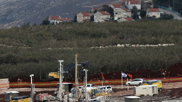 In this Thursday, Dec. 13, 2018 photo, Israeli military equipment works on the Lebanese-Israeli border in front of the Israeli town of Metula, background, near the southern village of Kafr Kila, Lebanon. As Israeli excavators dig into the rocky ground, Lebanese across the frontier gather to watch what Israel calls the Northern Shield operation aimed at destroying attack tunnels built by Hezbollah. But Lebanese soldiers in new camouflaged posts, behind sandbags, or inside abandoned homes underscore the real anxiety that any misstep could lead to a conflagration between the two enemy states that no one seems to want. - Sputnik International