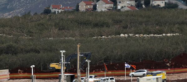 In this Thursday, Dec. 13, 2018 photo, Israeli military equipment works on the Lebanese-Israeli border in front of the Israeli town of Metula, background, near the southern village of Kafr Kila, Lebanon. As Israeli excavators dig into the rocky ground, Lebanese across the frontier gather to watch what Israel calls the Northern Shield operation aimed at destroying attack tunnels built by Hezbollah. But Lebanese soldiers in new camouflaged posts, behind sandbags, or inside abandoned homes underscore the real anxiety that any misstep could lead to a conflagration between the two enemy states that no one seems to want. - Sputnik International