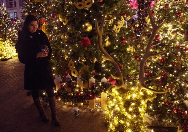 A tourist amidst New Year decorations on Manezhnaya Square A tourist amidst New Year decorations on Manezhnaya Square - Sputnik International