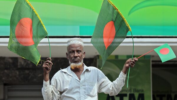 A Bangladeshi man waves national flags - Sputnik International