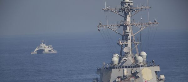The USS Mitscher, part of a strike group led by the USS John C. Stennis aircraft carrier, sails as an Iranian Revolutionary Guard vessel shadows it on Friday, Dec. 21, 2018. - Sputnik International