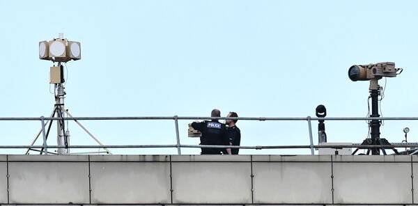 Police officers stand near equipment on the rooftop of a building at London Gatwick Airport, south of London, on December 21, 2018 - Sputnik International