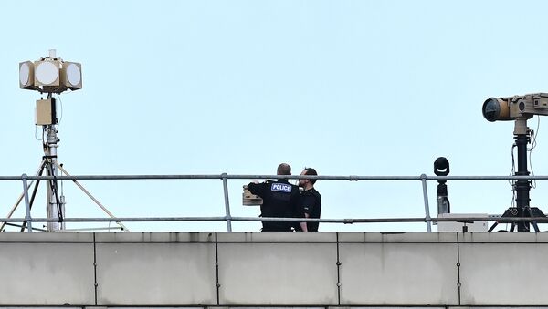 Police officers stand near equipment on the rooftop of a building at London Gatwick Airport, south of London, on December 21, 2018 - Sputnik International