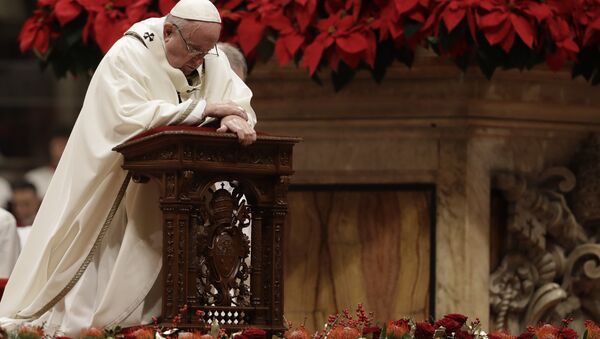 Pope Francis kneels on the altar as he celebrates the Christmas Eve Mass in St. Peter's Basilica at the Vatican, Monday, Dec. 24, 2018 - Sputnik International