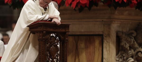 Pope Francis kneels on the altar as he celebrates the Christmas Eve Mass in St. Peter's Basilica at the Vatican, Monday, Dec. 24, 2018 - Sputnik International