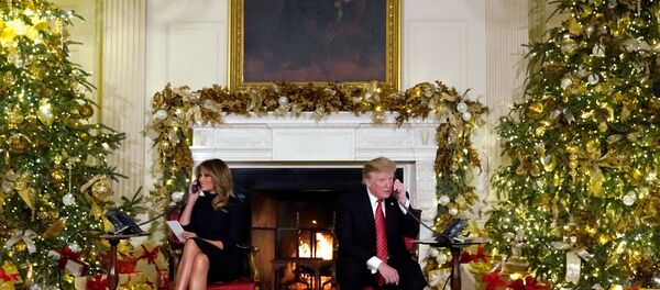 U.S. President Donald Trump and first lady Melania Trump participate in NORAD Santa tracker phone calls from the White House in Washington, U.S. December 24, 2018 - Sputnik International