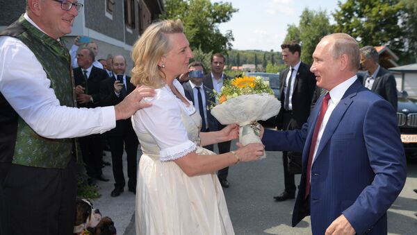 August 18, 2018. Russian President Vladimir Putin gives flowers to Austrian Foreign Minister Karin Kneissl during her wedding to entrepreneur Wolfgang Meilinger, left - Sputnik International