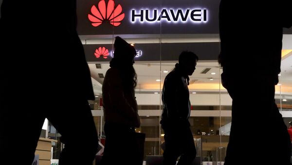 Pedestrians walk past a Huawei retail shop in Beijing Thursday, Dec. 6, 2018 - Sputnik International