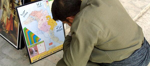 An Iraqi Kurd observes the kurdish enclave on an Iraqi map (File) - Sputnik International