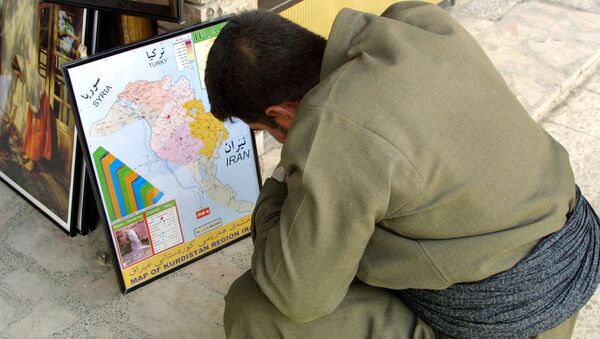 An Iraqi Kurd observes the kurdish enclave on an Iraqi map (File) - Sputnik International