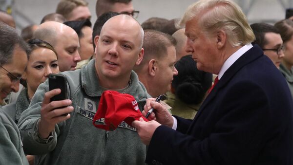 U.S. President Donald Trump signs a cap while visiting U.S. troops at Ramstein Air Force Base, Germany, December 27, 2018 - Sputnik International