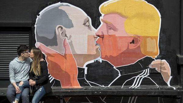 FILE - In this Saturday, May 14, 2016 file photo a couple kisses in front of graffiti depicting Russian President Vladimir Putin, left, and Republican presidential candidate Donald Trump, on the walls of a bar in the old town in Vilnius, Lithuania - Sputnik International