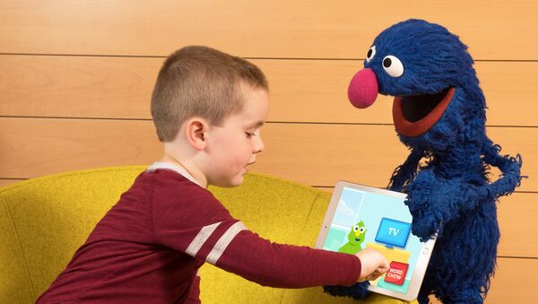 In this photo taken by Feature Photo Service for IBM: A child shows his friend Grover the new cognitive vocabulary learning app from IBM and Sesame Workshop. The app was recently piloted in Gwinnett County Public School System in Georgia to enhance students’ vocabulary development. - Sputnik International