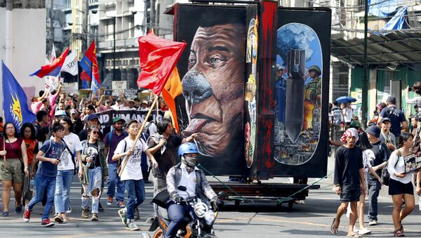Protesters march with a rotating effigy of Philippine President Rodrigo Duterte for a rally near the Presidential Palace to mark the UN Declaration of International Human Rights Day Monday, Dec. 10, 2018 in Manila, Philippines. The protesters accuse the President of alleged rampant human rights violations since taking office more than two years ago - Sputnik International