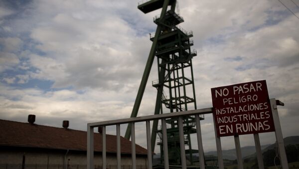 a banner reading in Spanish No entry, dangerous, industrial facilities are on the point of collapse is seen at the main entrance of La Camocha mine, abandoned five years ago because of the coal crisis in Hueces, near Gijon, Spain. - Sputnik International