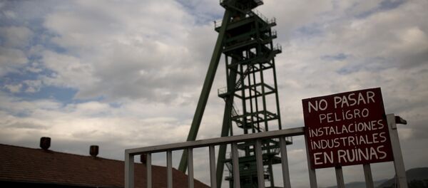 a banner reading in Spanish No entry, dangerous, industrial facilities are on the point of collapse is seen at the main entrance of La Camocha mine, abandoned five years ago because of the coal crisis in Hueces, near Gijon, Spain. - Sputnik International