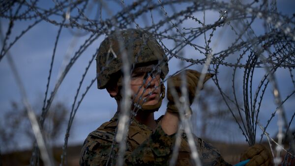 A soldier agent sets up barbed wire at the San Ysidro port of entry, at the U.S.-Mexico border, seen from Tijuana, Mexico, Thursday, Nov. 22, 2018 - Sputnik International