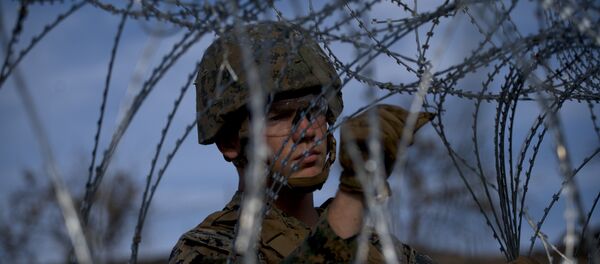 A soldier agent sets up barbed wire at the San Ysidro port of entry, at the U.S.-Mexico border, seen from Tijuana, Mexico, Thursday, Nov. 22, 2018 A soldier agent sets up barbed wire at the San Ysidro port of entry, at the U.S.-Mexico border, seen from Tijuana, Mexico, Thursday, Nov. 22, 2018 - Sputnik International