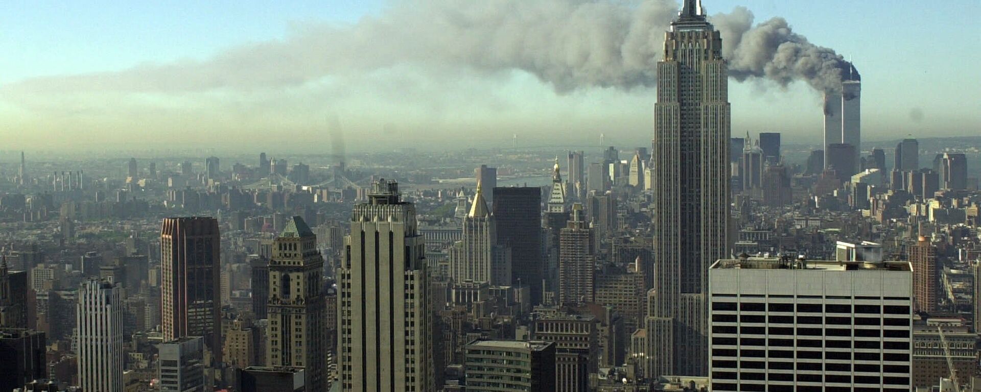 Plumes of smoke pour from the World Trade Center buildings in New York Tuesday, Sept. 11, 2001. Planes crashed into the upper floors of both World Trade Center towers minutes apart Tuesday in a horrific scene of explosions and fires that left gaping holes in the 110-story buildings - Sputnik International, 1920, 16.04.2020