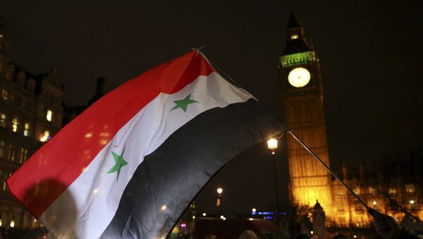 Anti-war protesters wave a Syrian flag as they demonstrate against proposals to bomb Syria outside the Houses of Parliament in London, Britain December 1, 2015. - Sputnik International