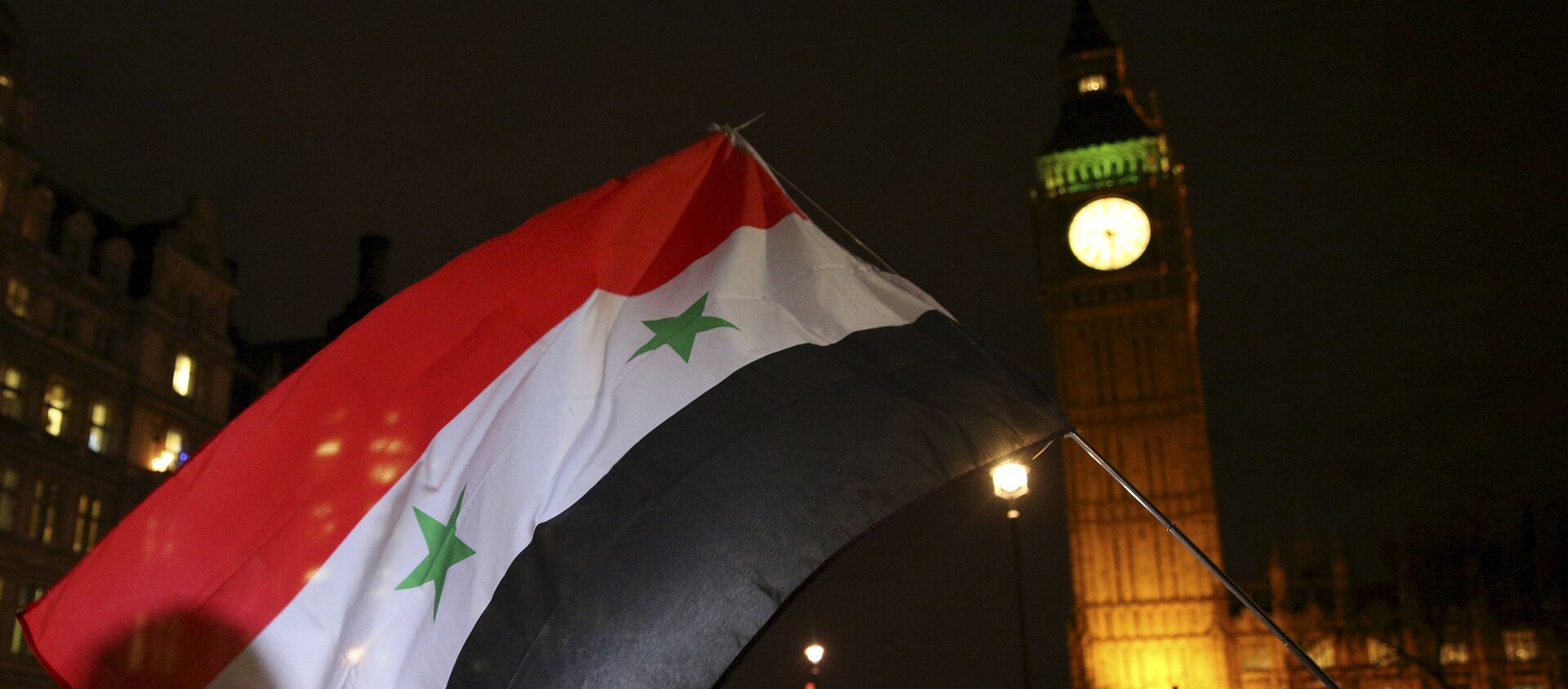 Anti-war protesters wave a Syrian flag as they demonstrate against proposals to bomb Syria outside the Houses of Parliament in London, Britain December 1, 2015. - Sputnik International, 1920, 19.09.2019