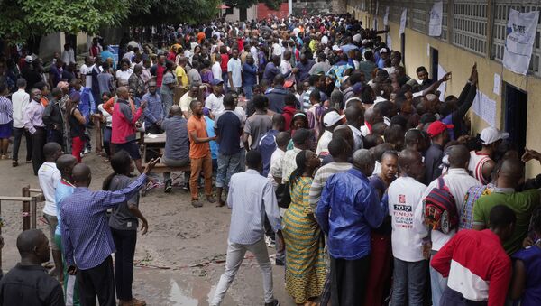 Hundreds of Congolese voters who have been waiting at the St. Raphael school in the Limete district of Kinshasa Sunday Dec. 30, 2018, storm the polling stations after the voters listings were finally posted five hours after the official start of voting. Forty million voters are registered for a presidential race plagued by years of delay and persistent rumors of lack of preparation. (AP Photo/Jerome Delay) - Sputnik International