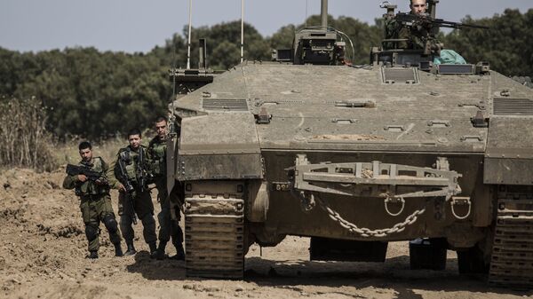 Israeli soldiers stand by a tank near the Israel Gaza border - Sputnik International