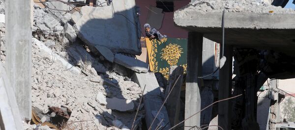 A Palestinian girl looks out from her family's house that witnesses said was destroyed by Israeli shelling during a 50-day war last summer, in Khan Younis in the southern Gaza Strip June 22, 2015. - Sputnik International