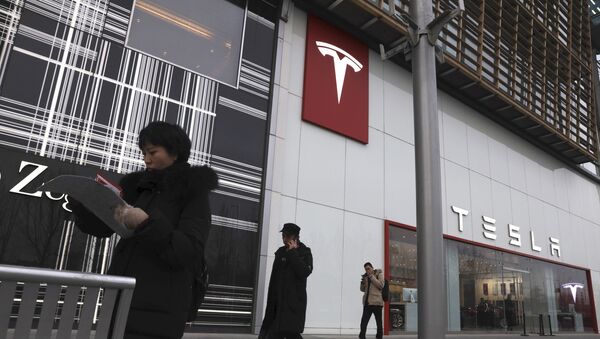 Residents walk past a Tesla store in Beijing - Sputnik International
