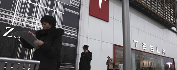 Residents walk past a Tesla store in Beijing - Sputnik International
