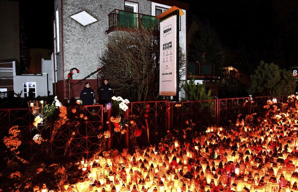 Lights, flowers and toys are left outside the escape room entertainment site where five teenage girls died in a fire last week, in Koszalin, northern Poland, on Sunday, Jan. 6, 2019. Sunday was designated a day of mourning and prayers in Koszalin for the girls and their families. - Sputnik International