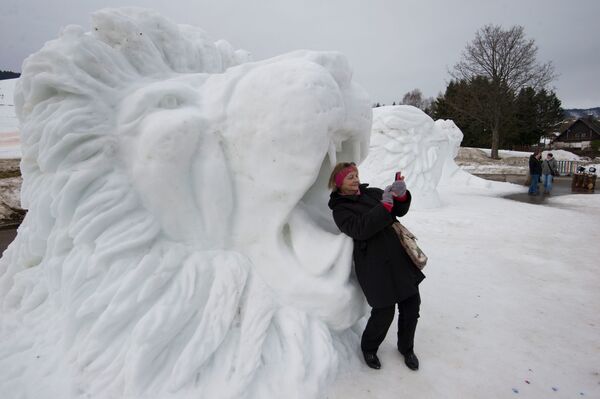 A Woman Takes a selfie in the Mouth of a Lion Snow Sculpture in Germany - Sputnik International