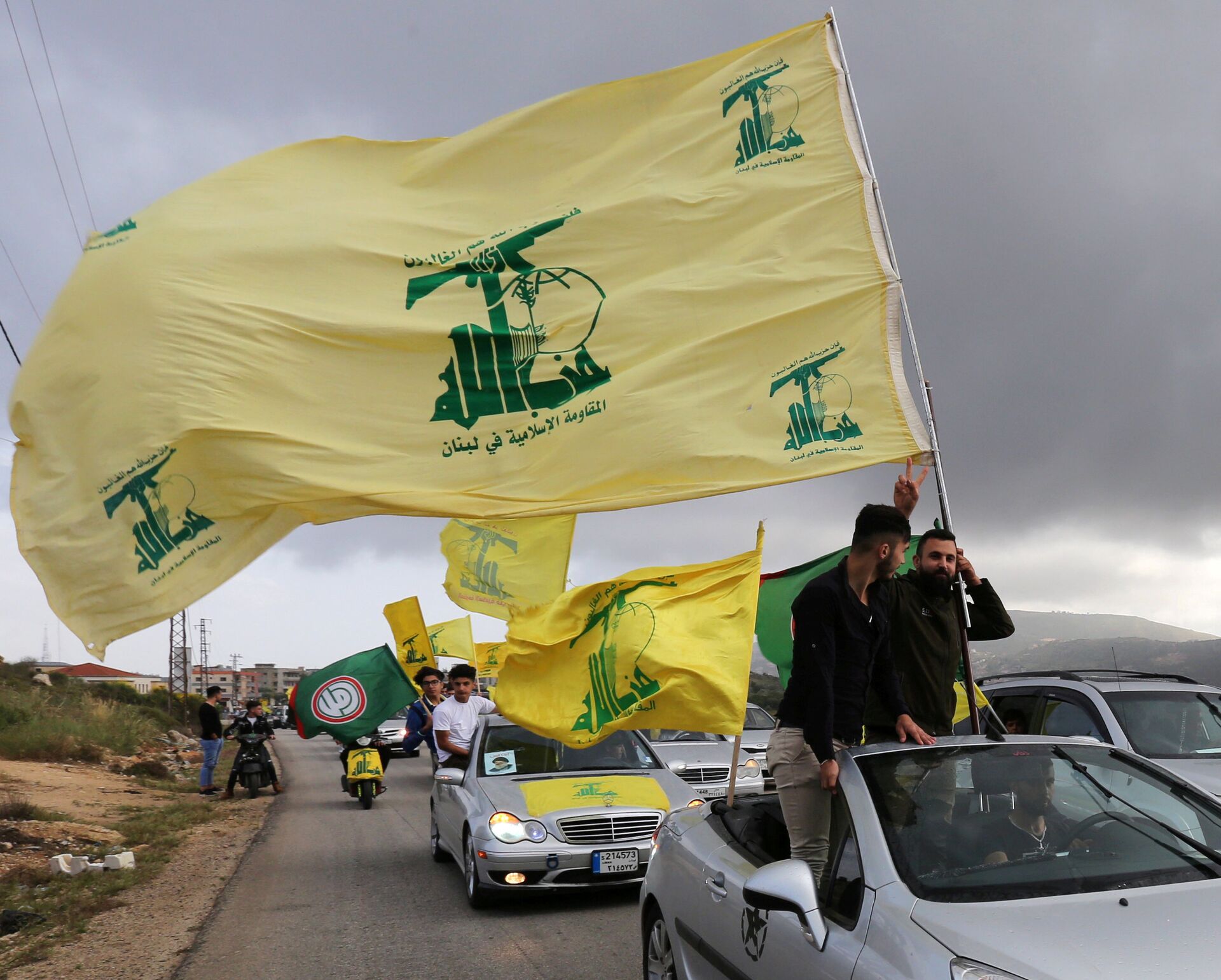 A supporter of Lebanon's Hezbollah gestures as he holds a Hezbollah flag in Marjayoun, Lebanon May 7, 2018 - Sputnik International, 1920, 13.05.2022