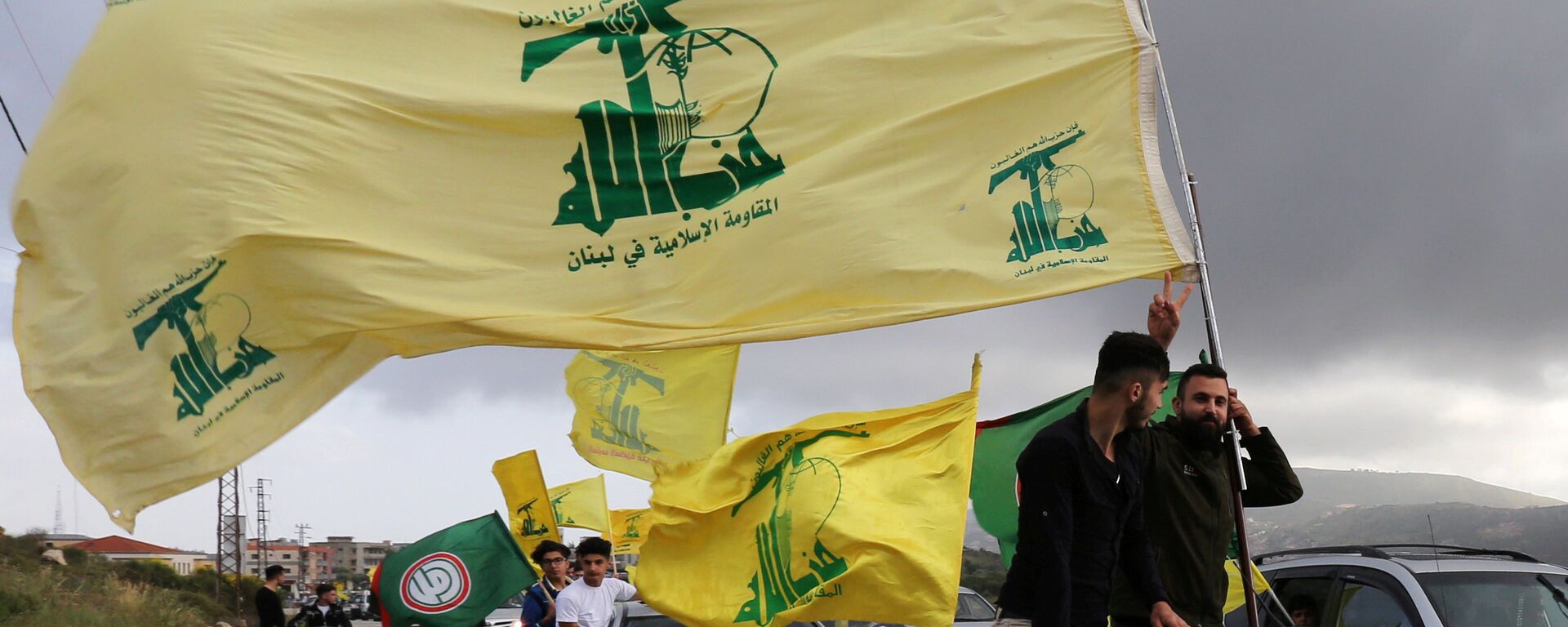 A supporter of Lebanon's Hezbollah gestures as he holds a Hezbollah flag in Marjayoun, Lebanon May 7, 2018 - Sputnik International, 1920, 23.10.2023