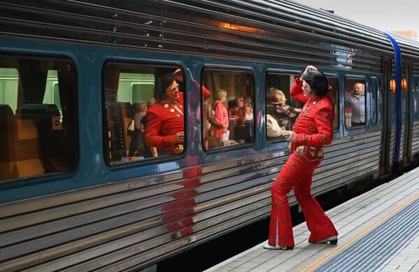 An Elvis fan uses a train window as a mirror at Central station before boarding a train to The Parkes Elvis Festival, in Sydney on January 10, 2019. - Sputnik International