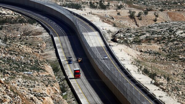 Cars drive on a new Israeli road divided by a wall to separate it for Palestinians (L) and the side to be used exclusively by Israelis and settlers (R) in East Jerusalem, on January 10, 2019 - Sputnik International