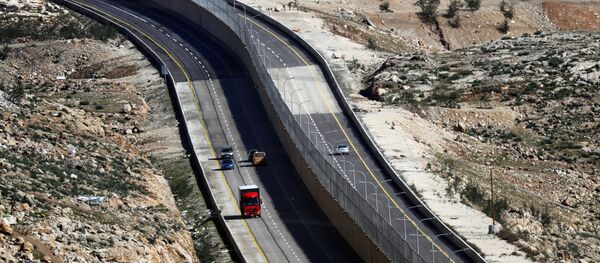 Cars drive on a new Israeli road divided by a wall to separate it for Palestinians (L) and the side to be used exclusively by Israelis and settlers (R) in East Jerusalem, on January 10, 2019 - Sputnik International