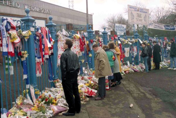 People looking at the hundreds of scarves and flowers which were left in tribute at Hillsborough in the aftermath of the disaster People looking at the hundreds of scarves and flowers which were left in tribute at Hillsborough in the aftermath of the disaster - Sputnik International