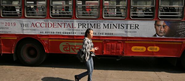 A woman walks past a bus featuring an advertising of the upcoming Bollywood film The Accidental Prime Minister in Mumbai, India, January, 5, 2019 - Sputnik International